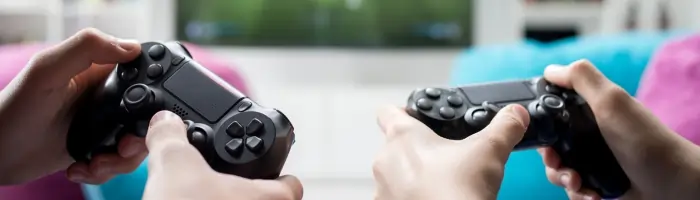 Two individuals are playing video games and holding gaming controllers